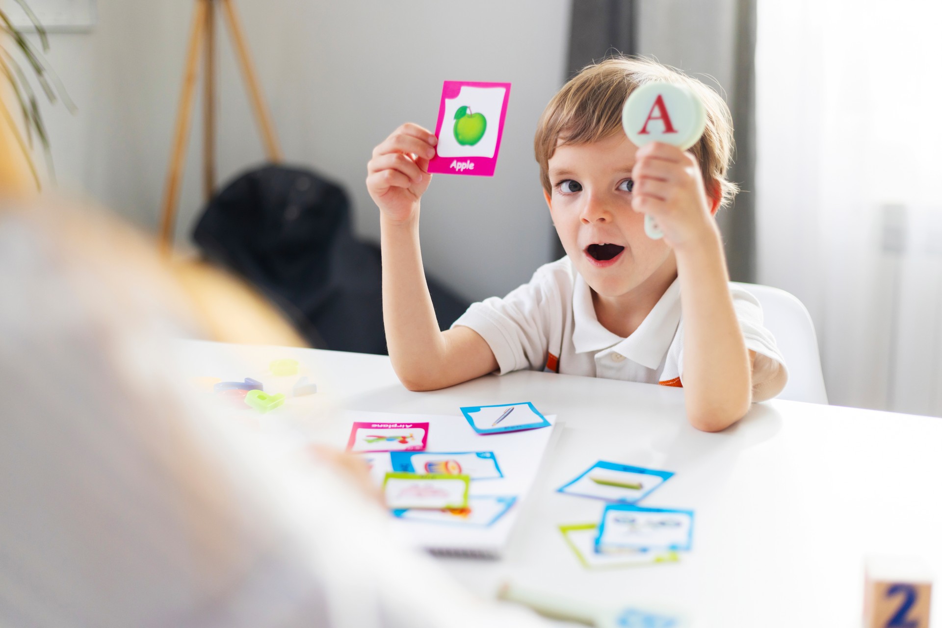 Child Learning Alphabet Cards at Table